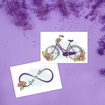 Lot de deux cartes postales rerésentant une bicyclette viollette et des fleurs rose corail et le sigle infini avec le texte free to ride