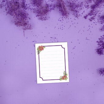 Petit bloc-notes représentant un cadre violet et des fleurs rose corail