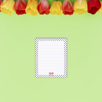 Petit bloc-notes représentant un petit nœud rose avec un contour de pois noirs