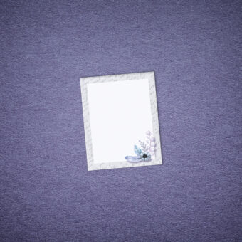 Petit bloc-notes représentant une fleur et des plumes bleues et violettes avec un contour de textes calligraphiés gris